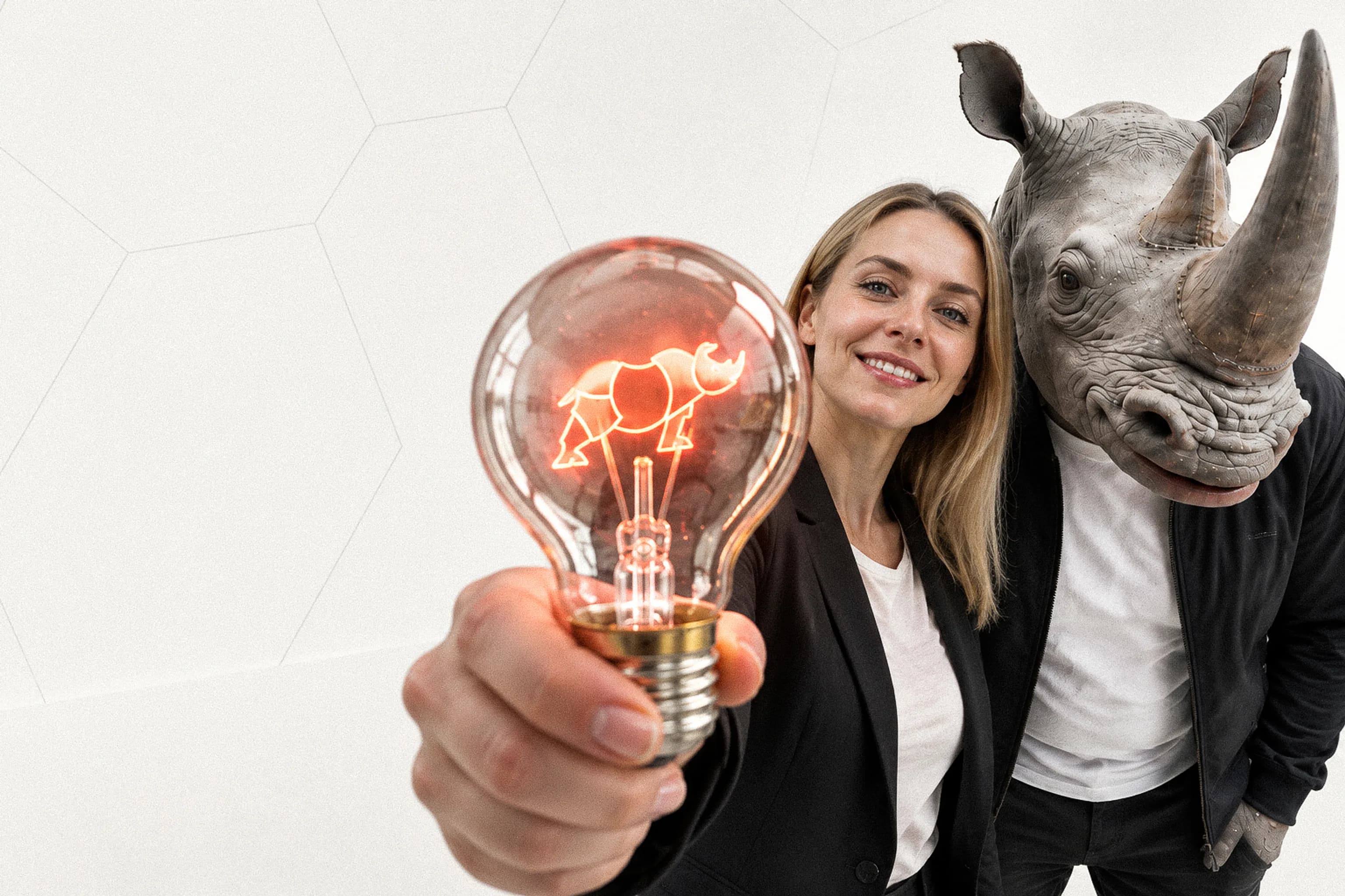 Tout autre secteur : une professionnelle tend une ampoule au filament en forme de rhinocéros, à côté d’un personnage à tête de rhinocéros