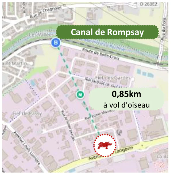 Plan du quartier : un trait pointillé relie un cercle rouge marqué du rhinocéros du logo, en bas du plan, au Canal de Rompsay, en haut ; une étiquette indique « 0,85km à vol d’oiseau ».